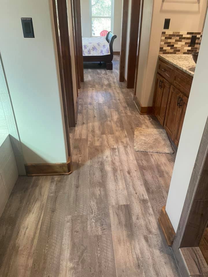 Wood-look laminate flooring installed in a Central Texas hallway — affordable hardwood alternative by Heart of Texas Flooring