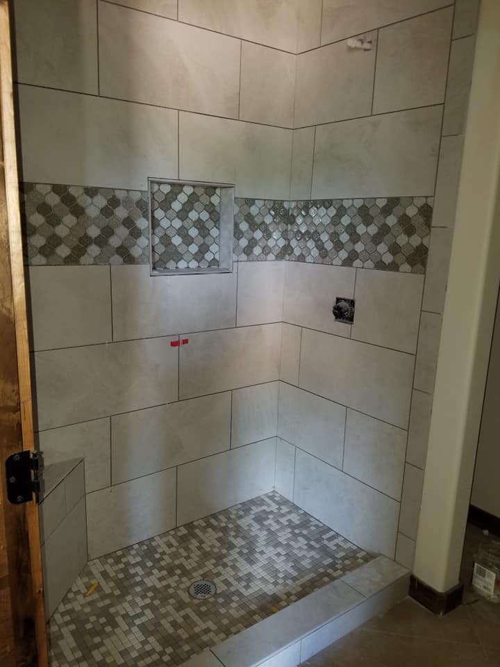 Custom mosaic accent tile shower installation in a Central Texas bathroom by Heart of Texas Flooring